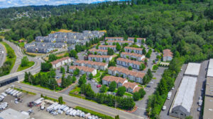 Aerial Exterior Of Silver Springs and surrounding communities, dense woods behind property, leasing office left side of street entrance.